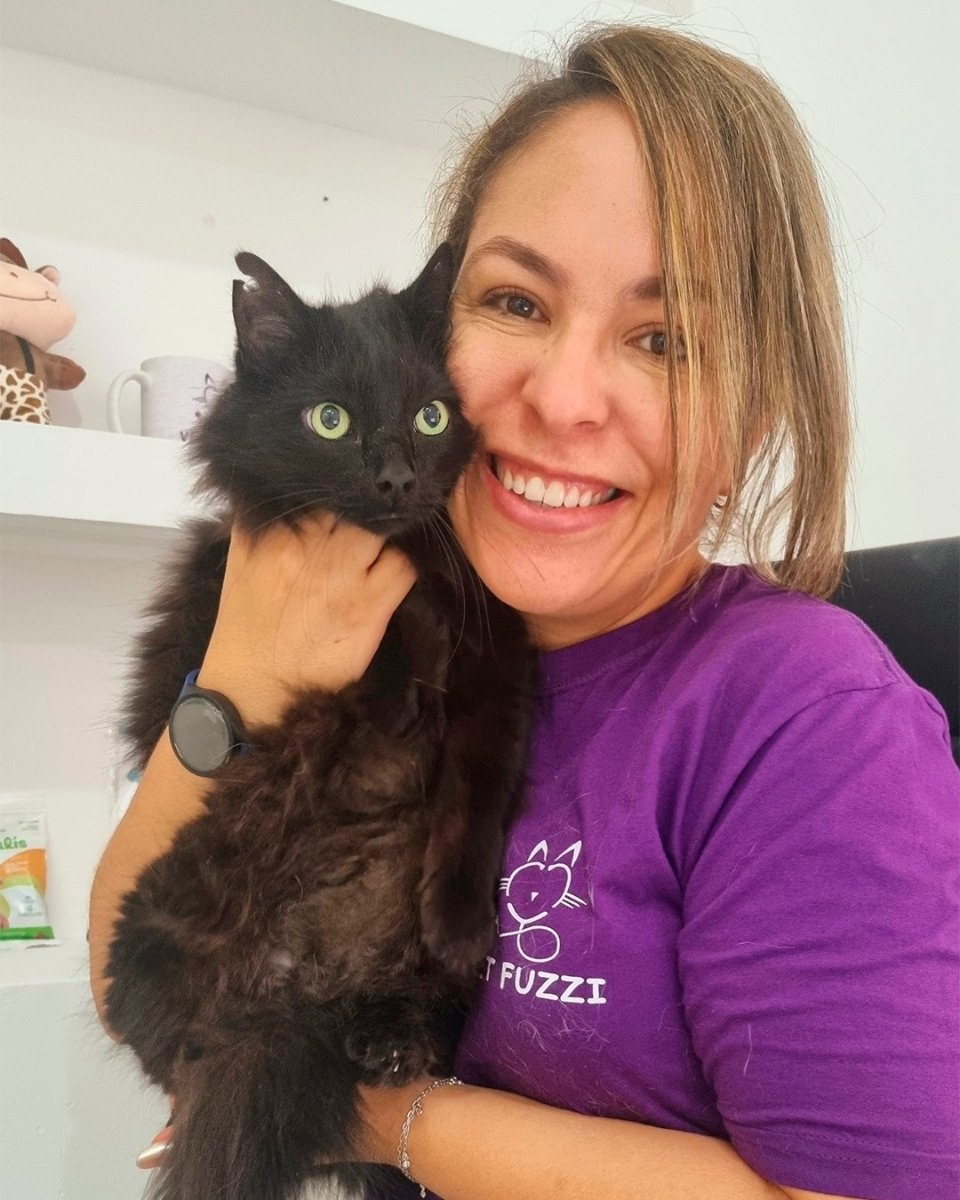 Veterinária com gato preto no colo